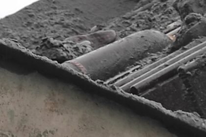 2.Pociska artytleryjski lezacy na metalowych elemetach maszyny do segregowania zwiru